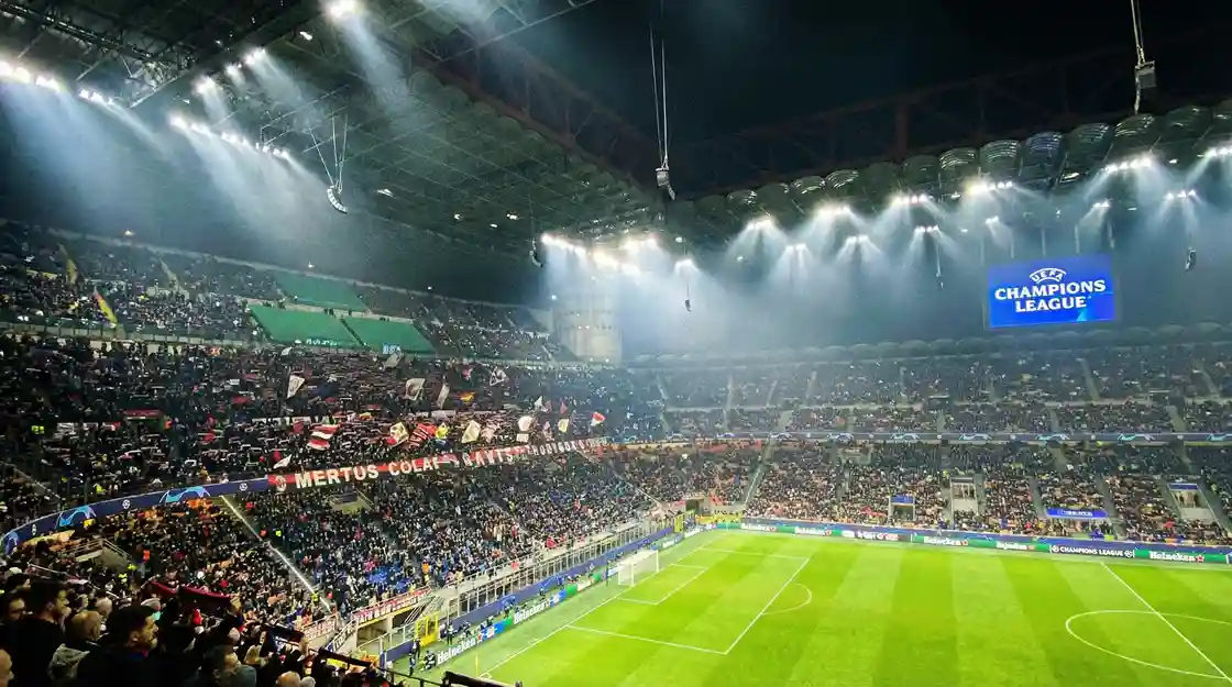 Estadio de fútbol europeo iluminado de noche para un partido de Champions League