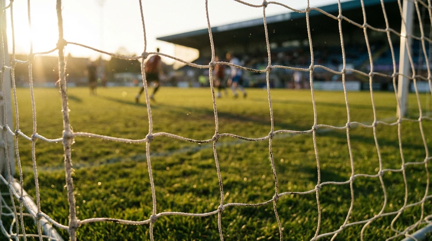 Red de portería de fútbol vista desde dentro del arco con el campo al fondo